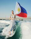 Expat surfs in high heels with Philippines flag to honour Filipino community4
